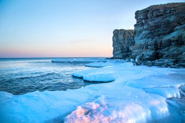 Yüksek kayalıklarla tüm içinde buz denizi ne dökülür. Buzun içinde kaya gün batımında. gelen giden güzel bir manzara güneş.