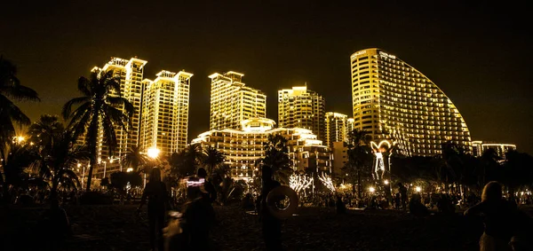 Cidade noturna Sanya todas as luzes, luzes brilhantes adornam o edifício. os trópicos . — Fotografia de Stock