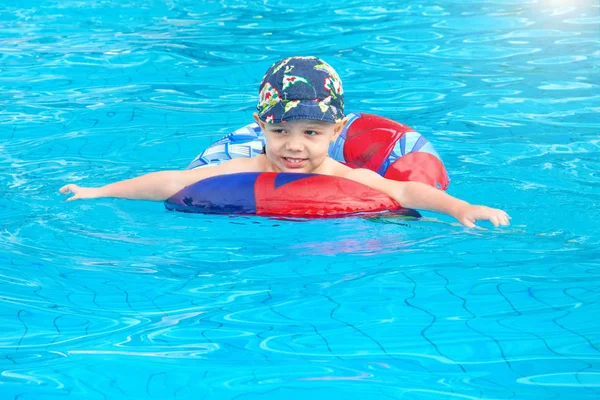 Niño nada, niño alegre saltando en la piscina en el círculo, piscina al aire libre , —  Fotos de Stock