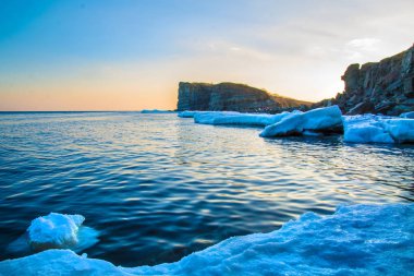 Yüksek kayalıklarla tüm içinde buz denizi ne dökülür. Buzun içinde kaya gün batımında. gelen giden güzel bir manzara güneş.