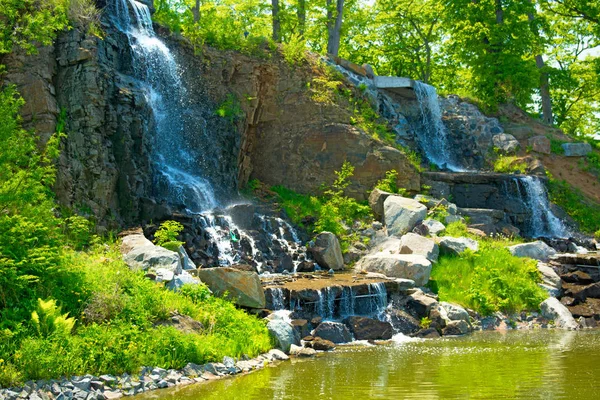 güneş ışığı, yeşil ormanlarla çevrili çok güzel su jetleri altında güzel şelale. 