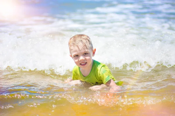 小さな男の子を実行し、純粋な波のしぶき、海で泳いで. — ストック写真