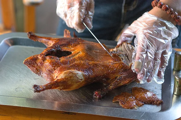 Cook cut up a juicy duck Peking, beautiful, bright and tasty dish that is ready to supply the cook.