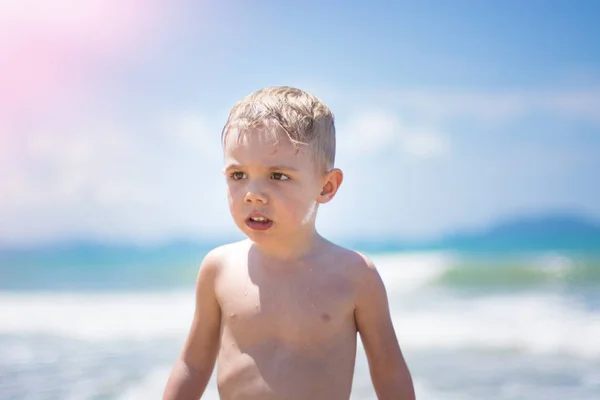 Úszhat a tengerben, futás és hullámok tiszta fröccsen kisfiú. — Stock Fotó