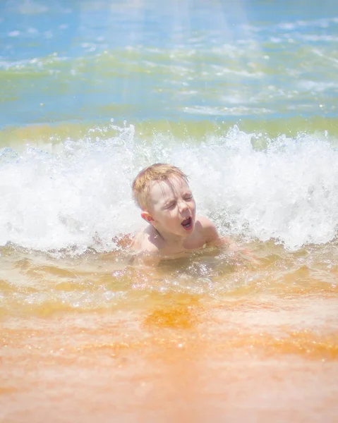 小さな男の子を実行し、純粋な波のしぶき、海で泳いで. — ストック写真