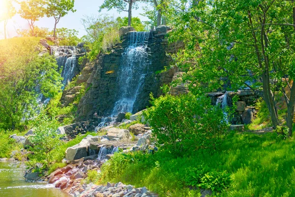 Hermosa cascada bajo la luz del sol, muchos chorros de agua hermosa rodeada de bosques verdes . — Foto de Stock