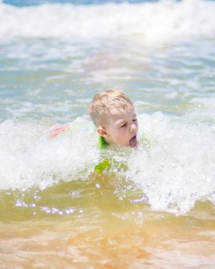 küçük çocuk çalışan ve saf dalgalarda sıçramasına deniz yüzme.