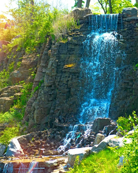Hermosa cascada bajo la luz del sol, muchos chorros de agua hermosa rodeada de bosques verdes . —  Fotos de Stock