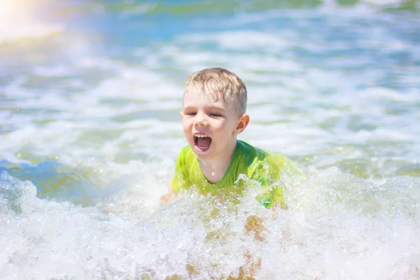 小さな男の子を実行し、純粋な波のしぶき、海で泳いで. — ストック写真