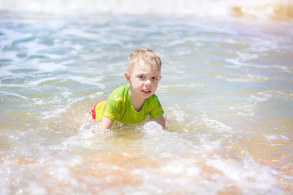 小さな男の子を実行し、純粋な波のしぶき、海で泳いで. — ストック写真