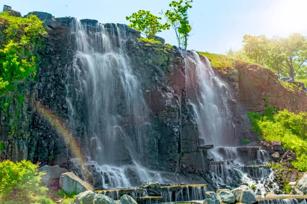 Hermosa cascada bajo la luz del sol, muchos chorros de agua hermosa rodeada de bosques verdes . — Foto de Stock