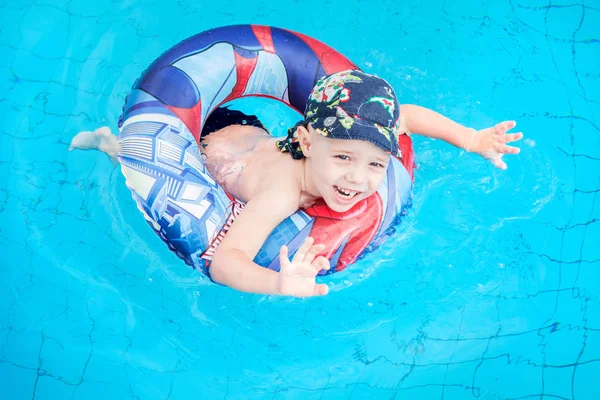 小さな男の子が泳ぐと、ジャンプ サークル、屋外スイミング プールでは、プールで元気な子, — ストック写真