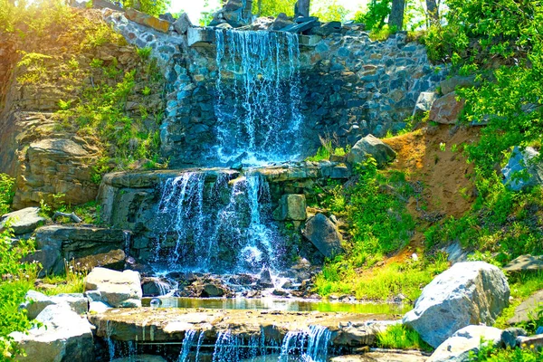 Beautiful waterfall under sunlight, many beautiful water jets surrounded by green forests. — Stock Photo, Image