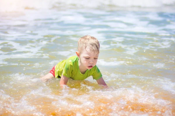 小さな男の子を実行し、純粋な波のしぶき、海で泳いで. — ストック写真