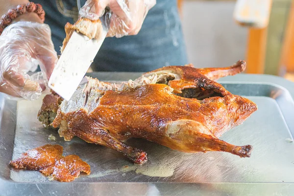 Cook cut up a juicy duck Peking, beautiful, bright and tasty dish that is ready to supply the cook. — Stock Photo, Image