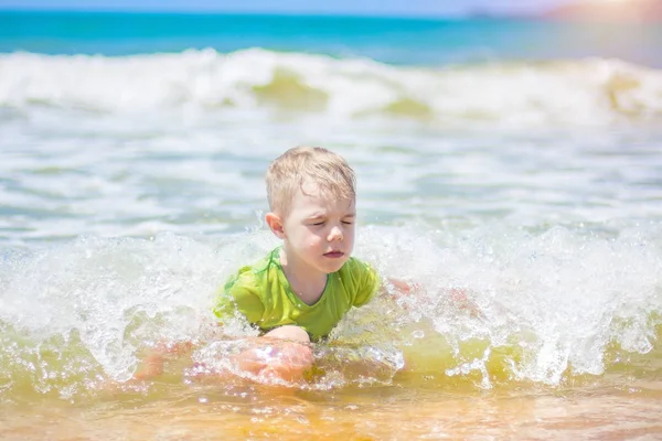 小さな男の子を実行し、純粋な波のしぶき、海で泳いで. — ストック写真