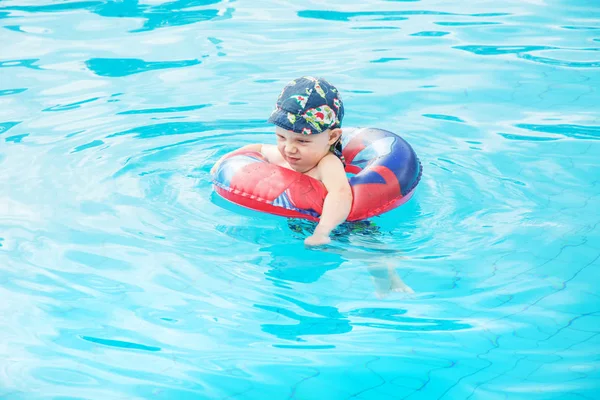 小さな男の子が泳ぎ 元気な子のサークル 屋外スイミング プール スプラッシュ プール内にジャンプ — ストック写真