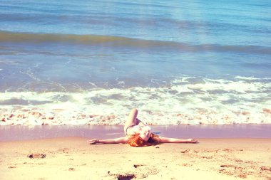 güzel kız bikini ıssız bir sahilde poz. beyaz kum, turkuaz deniz ve bir genç kız.