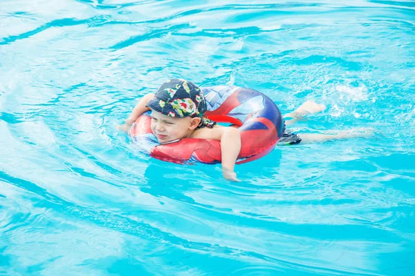 Niño nada, niño alegre saltando en la piscina en el círculo, piscina al aire libre , —  Fotos de Stock