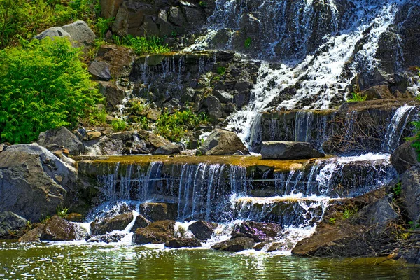 Bela cachoeira sob a luz do sol, muitos jatos de água bonita cercada por florestas verdes . — Fotografia de Stock