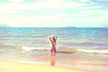 güzel kız bikini ıssız bir sahilde poz. beyaz kum, turkuaz deniz ve bir genç kız.