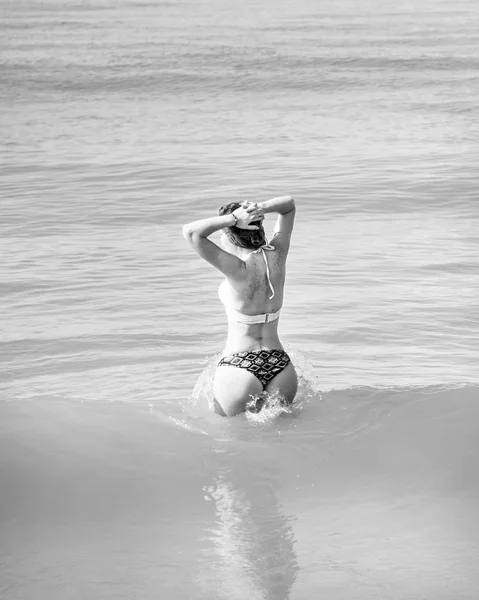 Mooi meisje in bikini poseren op een verlaten strand. wit zand, turquoise zee en een jong meisje. — Stockfoto