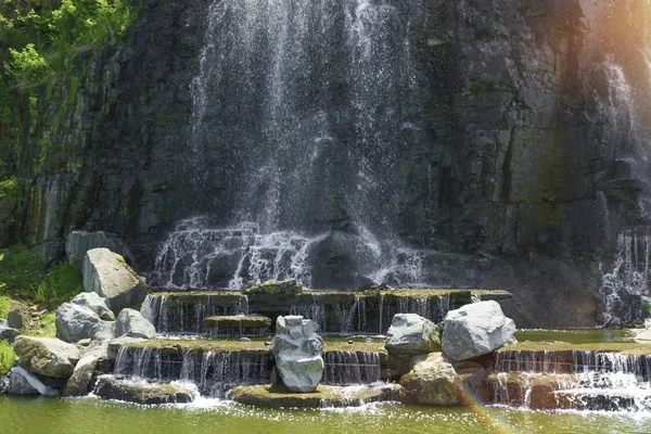 Belle cascade sous la lumière du soleil, de nombreux beaux jets d'eau entourés de forêts vertes . — Photo