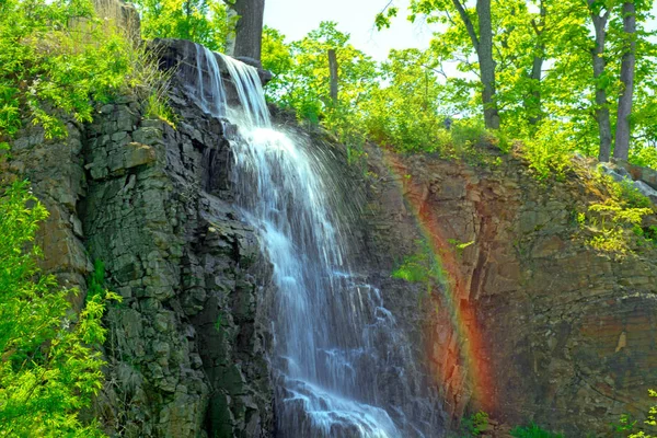 Beautiful waterfall under sunlight, many beautiful water jets surrounded by green forests. — Stock Photo, Image