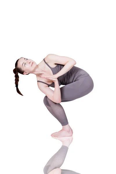 Jong meisje voert verschillende poses van yoga, flexibele mooie model op een witte achtergrond. meditatie en asana 's. — Stockfoto