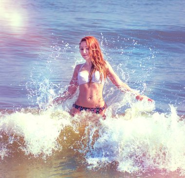 güzel kız bikini ıssız bir sahilde poz. beyaz kum, turkuaz deniz ve bir genç kız.