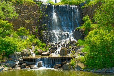 güneş ışığı, yeşil ormanlarla çevrili çok güzel su jetleri altında güzel şelale. 