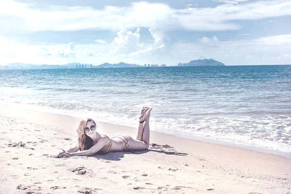 Menina bonita em biquíni posando em uma praia deserta. areia branca, mar azul-turquesa e uma jovem . — Fotografia de Stock