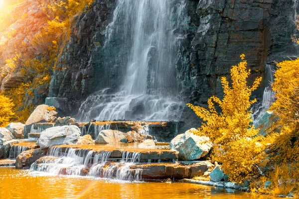 Hermosa cascada bajo la luz del sol, muchos chorros de agua hermosa rodeada de bosques verdes . — Foto de Stock