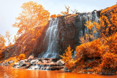güneş ışığı, yeşil ormanlarla çevrili çok güzel su jetleri altında güzel şelale. 
