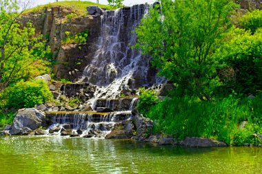 güneş ışığı, yeşil ormanlarla çevrili çok güzel su jetleri altında güzel şelale. 