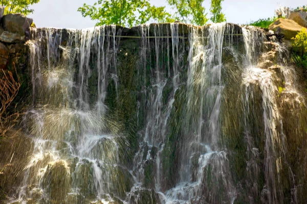 Belle cascade sous la lumière du soleil, de nombreux beaux jets d'eau entourés de forêts vertes . — Photo