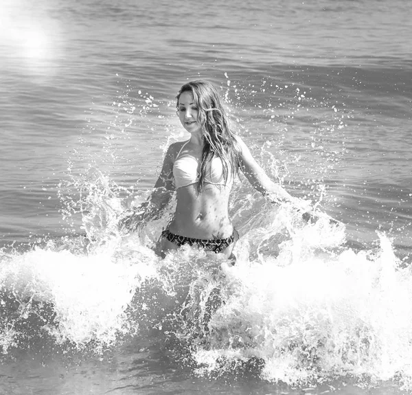 Vacker flicka i bikini poserar på en öde strand. vit sand, turkost hav och en ung flicka. — Stockfoto