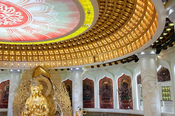 Das Zentrum des Buddhismus in Sanya. Tempel mit Lotus an der Decke, goldenem Buddha und vielen Statuen und Göttinnen. — Stockfoto