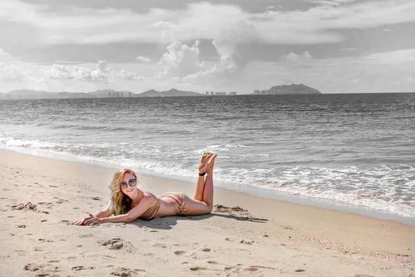 Menina bonita em biquíni posando em uma praia deserta. areia branca, mar azul-turquesa e uma jovem . — Fotografia de Stock