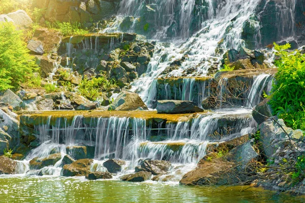 Hermosa cascada bajo la luz del sol, muchos chorros de agua hermosa rodeada de bosques verdes . — Foto de Stock