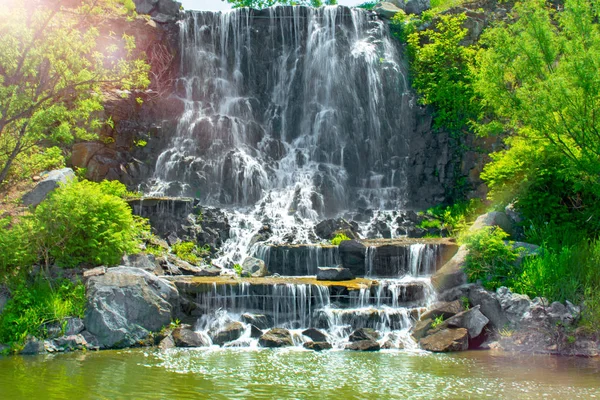 Bela cachoeira sob a luz do sol, muitos jatos de água bonita cercada por florestas verdes . — Fotografia de Stock