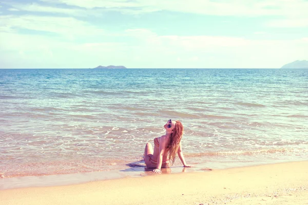 Mooi meisje in bikini poseren op een verlaten strand. wit zand, turquoise zee en een jong meisje. — Stockfoto