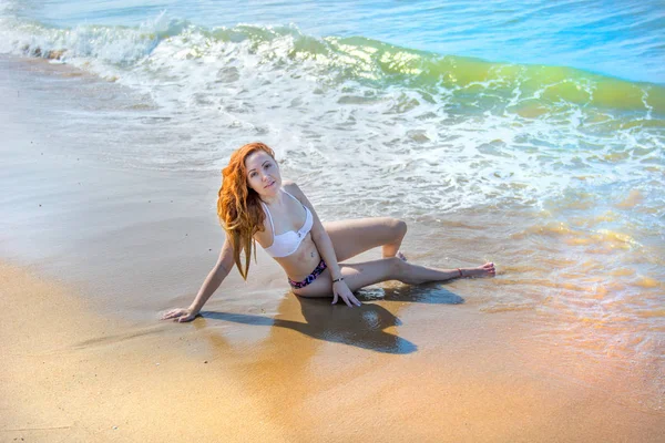 Schönes Mädchen im Bikini, das an einem einsamen Strand posiert. weißer Sand, türkises Meer und ein junges Mädchen. — Stockfoto