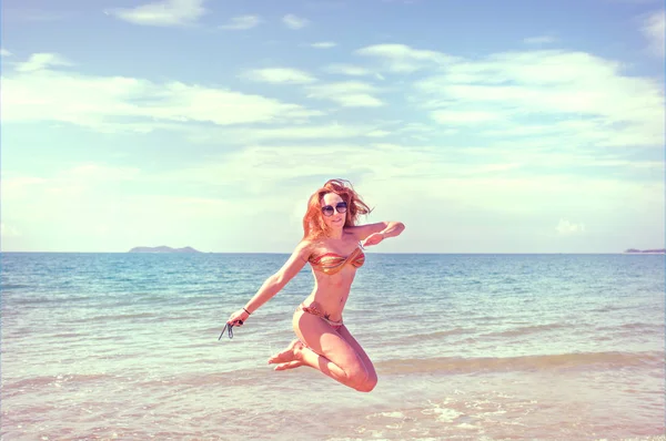 Menina bonita em biquíni posando em uma praia deserta. areia branca, mar azul-turquesa e uma jovem . — Fotografia de Stock