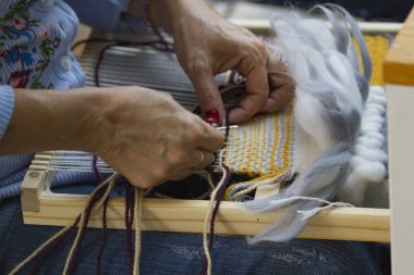 Tejido en telar dikey manos trabajando lana azul y amarillo tejiendo tapiz con hilo de algodn