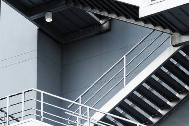 Escaleras de acil de plata en edificio gris de nueva construccion para acil con lampara vista desde abajo