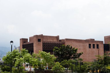 Teatro Metropolitano de medellin vista desde Parques del rio y cielo blanco