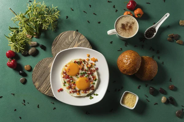 Huevos fritos con tocineta pepino rojo y verde pan y çikolatalı en fondo verde