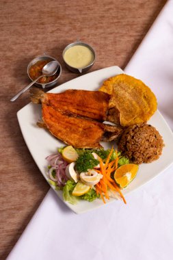 Pescado frito con arroz de coco y platano frito acompaado con ensalada de championes y zanahoria. Vista desde arriba de plato Geleneksel de la costa atlntica. 