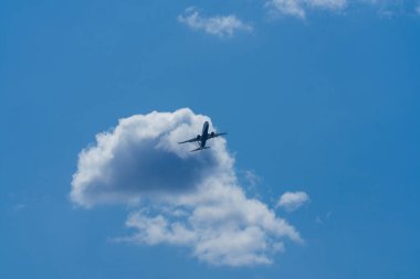 Geniş çekim fotoğraf ek yükü bir bulut geçen bir ticari havayolu jet uçuş gökyüzüne bakıyordum. Yolcu sinek Havacılık hizmet şirketleri kullanarak dünyanın her yerinden büyük bir iş olduğunu